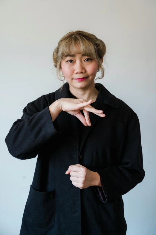 a woman making a heart sign with her hands, inspired by Kanō Naizen, wearing black overcoat, pokimane, round-cropped, profile image