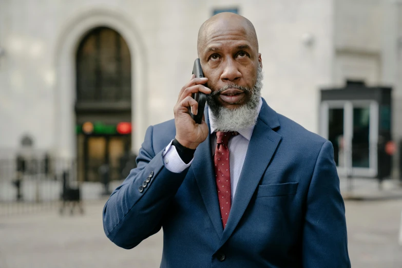 a man in a suit talking on a cell phone, inspired by William H. Mosby, pexels contest winner, bald head and white beard, ray lewis, atiba jefferson, ready for a meeting