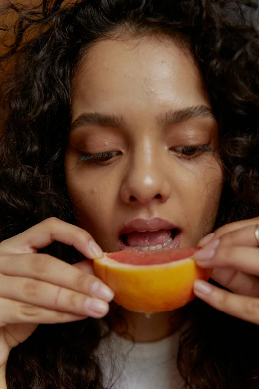 a close up of a person eating an orange, flawless olive skin, opening shot, rituals, pose 4 of 1 6