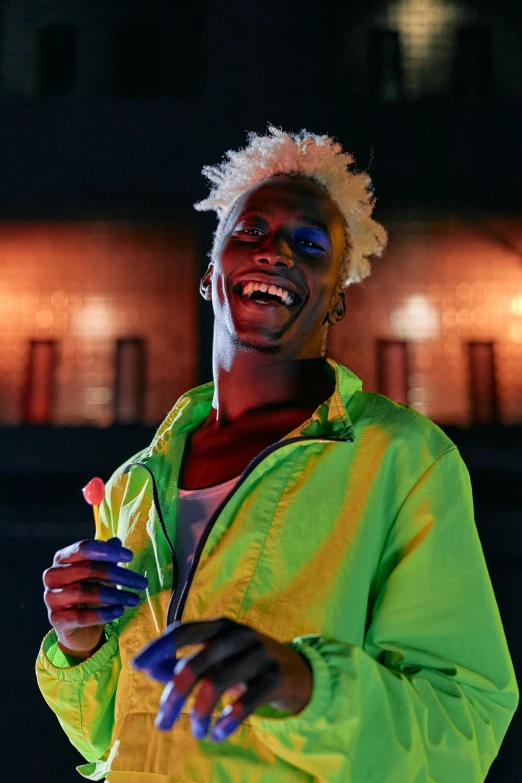 a man in a yellow jacket holding a pair of scissors, an album cover, trending on pexels, visual art, neon hair, brown skin man with a giant grin, ((neon colors)), night shot