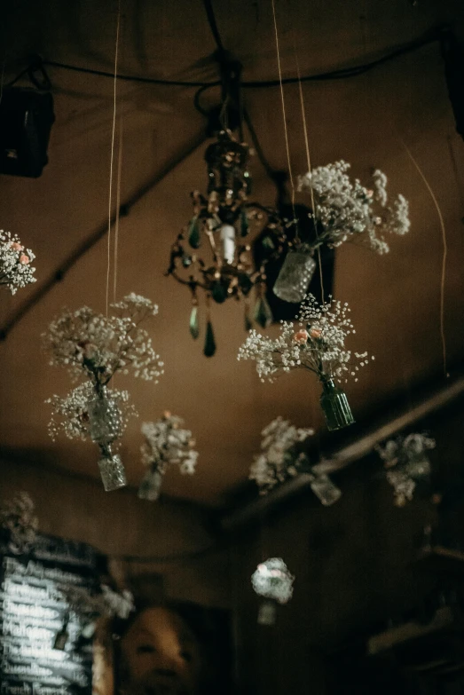 a bunch of lights hanging from the ceiling, by Elsa Bleda, trending on unsplash, baroque, gypsophila, made of dried flowers, rustic setting, low quality photo