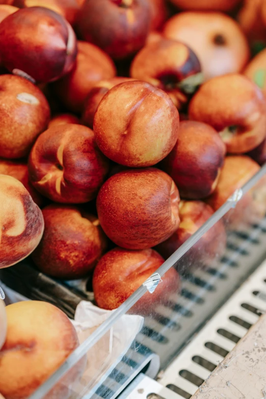 a pile of peaches sitting on top of a table, inside a supermarket, hands on counter, subtle detailing, walking down