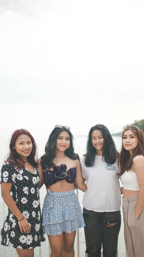 a group of women standing next to each other, unsplash, realism, low quality photo, croptop, seaview, student