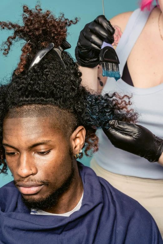 a man getting his hair cut by a woman, an album cover, trending on pexels, renaissance, a black man with long curly hair, teal hair, half and half dye, behind the scenes photo