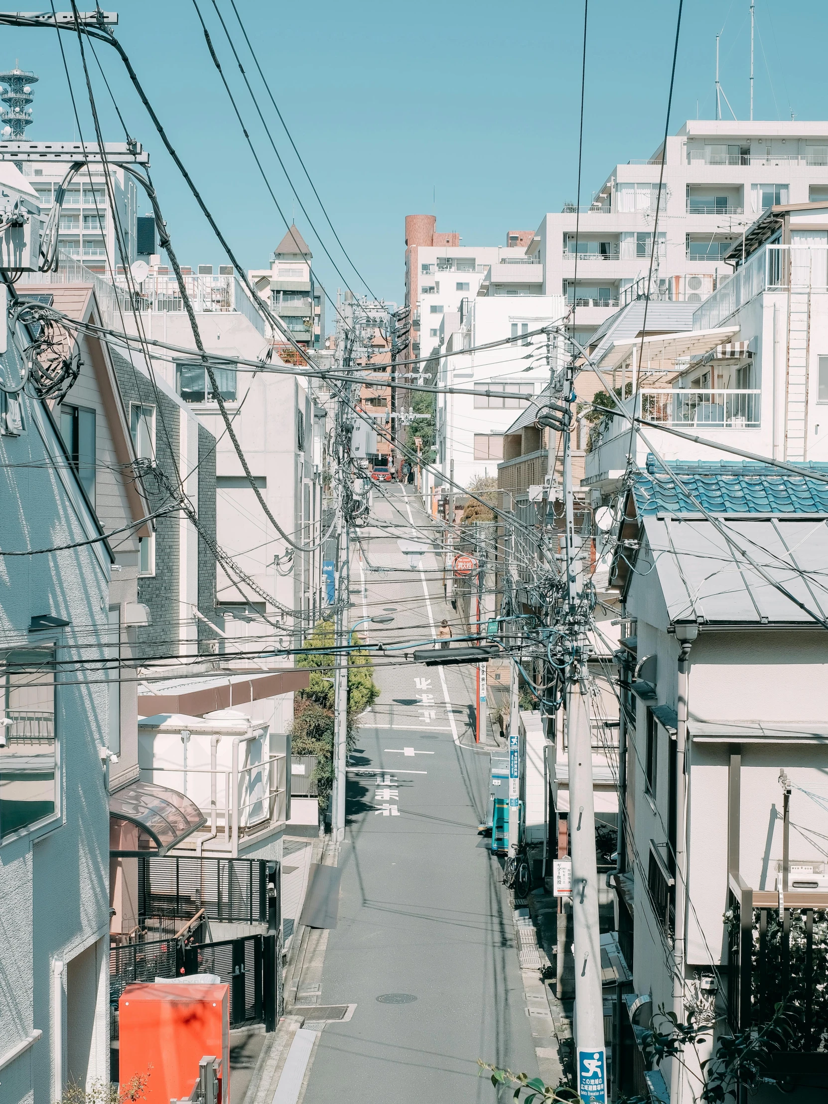 a city street filled with lots of tall buildings, inspired by Miyagawa Chōshun, trending on unsplash, exposed wires, shady alleys, japan shonan enoshima, trending on vsco