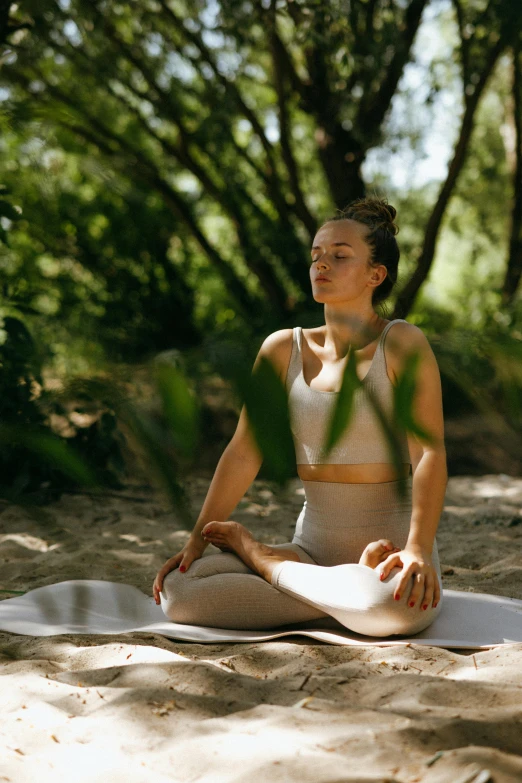 a woman sitting on a yoga mat in the woods, a portrait, unsplash, soft shade, lotus pose, in australia, spa