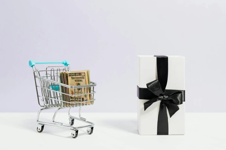 a shopping cart with money in it next to a gift box, pexels contest winner, modernism, set against a white background, at checkout, thumbnail, instagram post