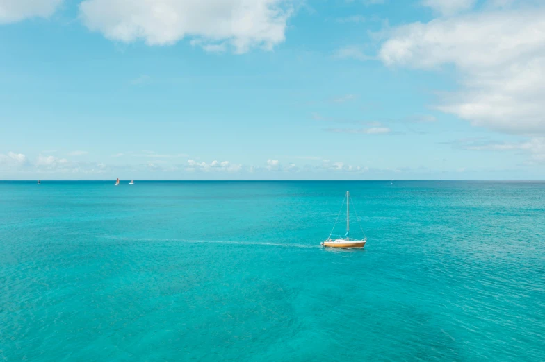 a boat floating in the middle of the ocean, by Simon Marmion, pexels contest winner, carribean turquoise water, slim aarons, sailboats, 8 k hi - res