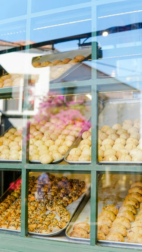 a display case filled with lots of baked goods, pexels, stood outside a corner shop, puffballs, thumbnail, square