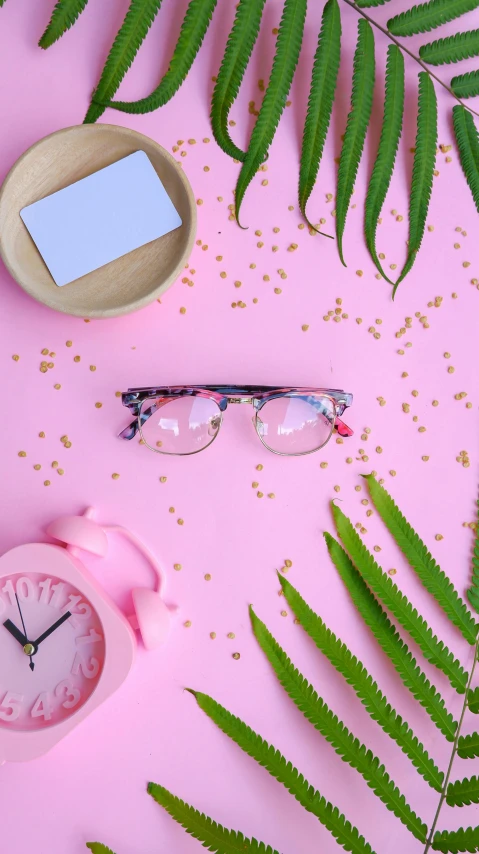 a pink clock and a pair of glasses on a pink surface, trending on pexels, maximalism, plants in glasses, speckled, thumbnail, patterned