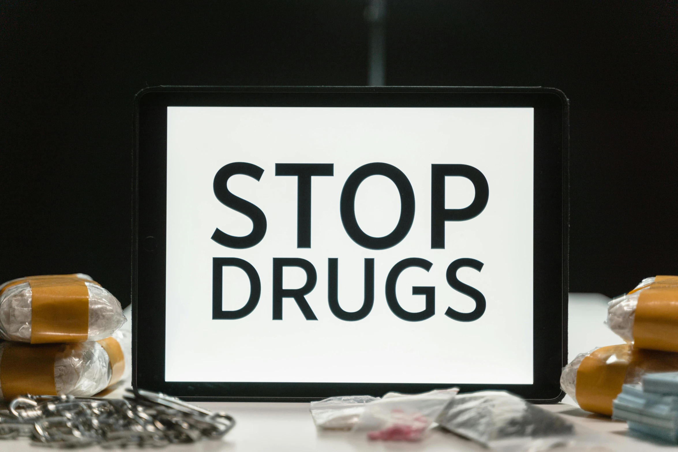 a tablet computer sitting on top of a table, shutterstock, antipodeans, drugs, stop sign, brown, drag