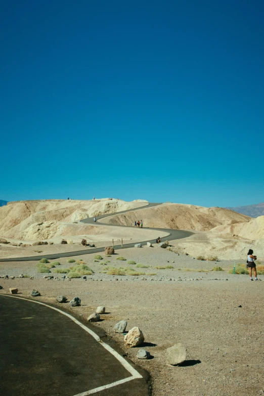 a couple of people that are standing in the dirt, unsplash, process art, road california desert, panoramic, hot summer day, sulfur