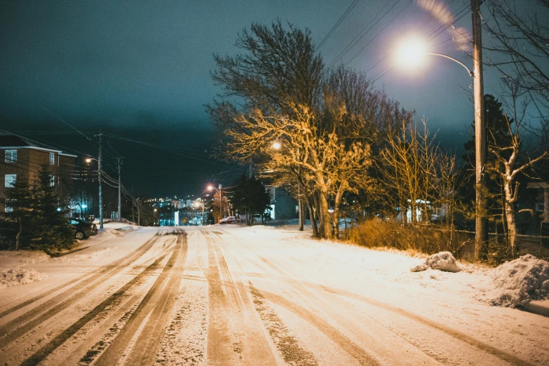 a street filled with lots of snow next to a street light, night-time, treacherous road, unsplash photography, quebec