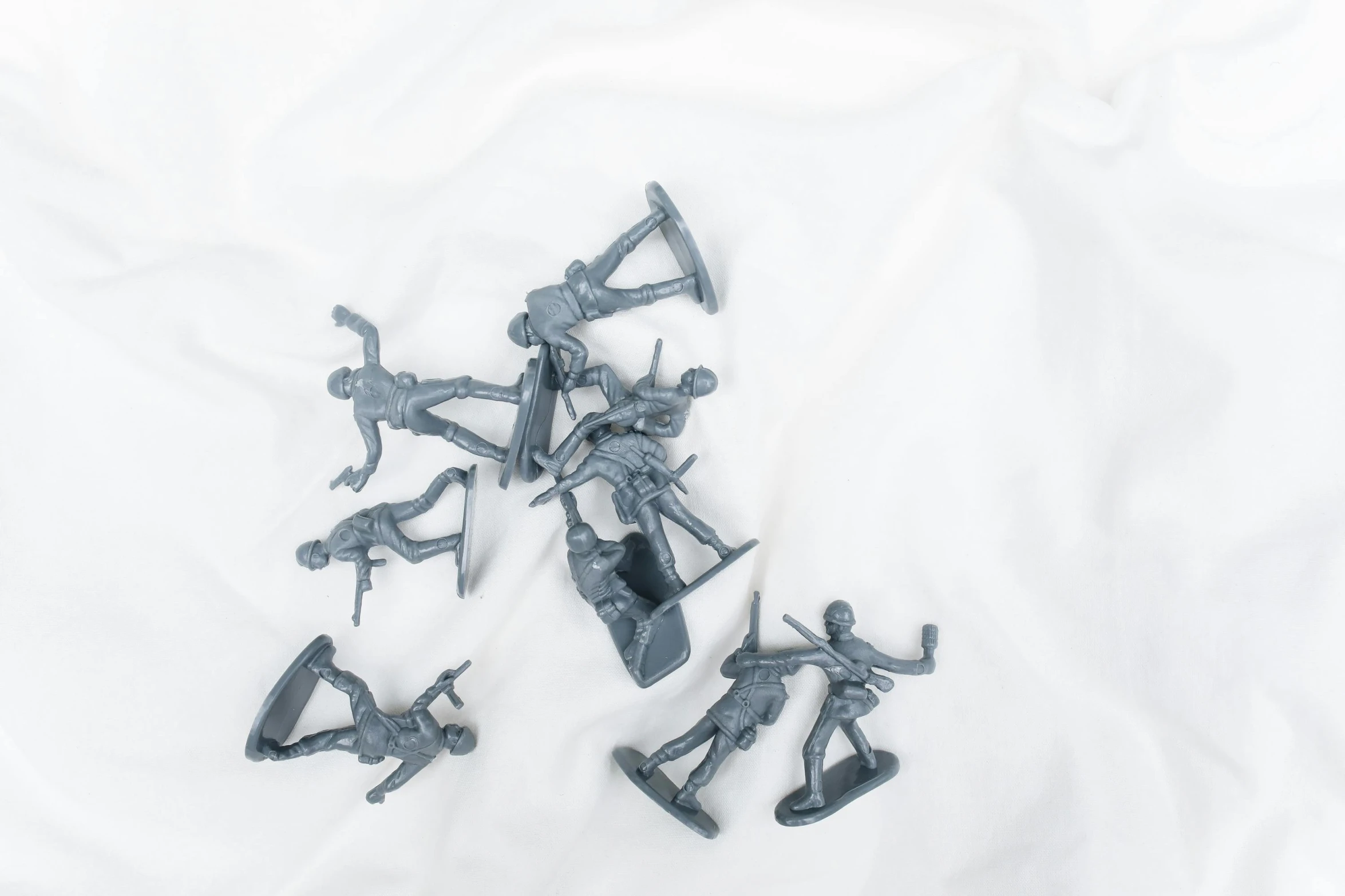 a group of toy soldiers sitting on top of a white sheet, gun metal grey, product shot, the falling soldier, product image