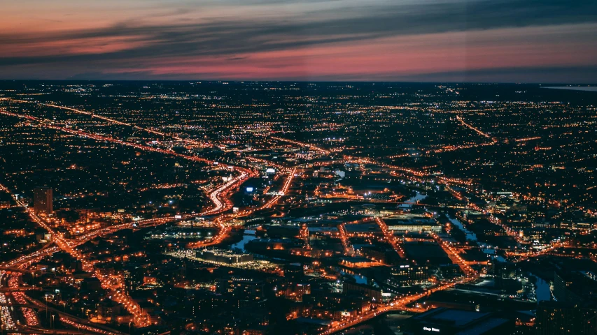 an aerial view of a city at night, a screenshot, by Adam Marczyński, pexels contest winner, light illumination at sunset, hannover, low detailed, landscape photo