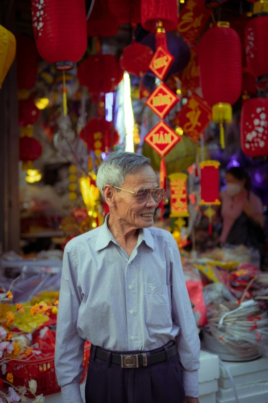 a man that is standing in front of a store, inspired by Cui Bai, pexels contest winner, colorful paper lanterns, portrait of an old man, slide show, vietnamese temple scene