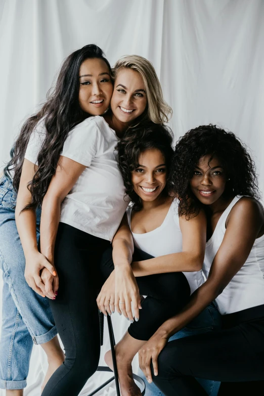 a group of women sitting next to each other, trending on pexels, portrait of women embracing, an all white human, wavy, college