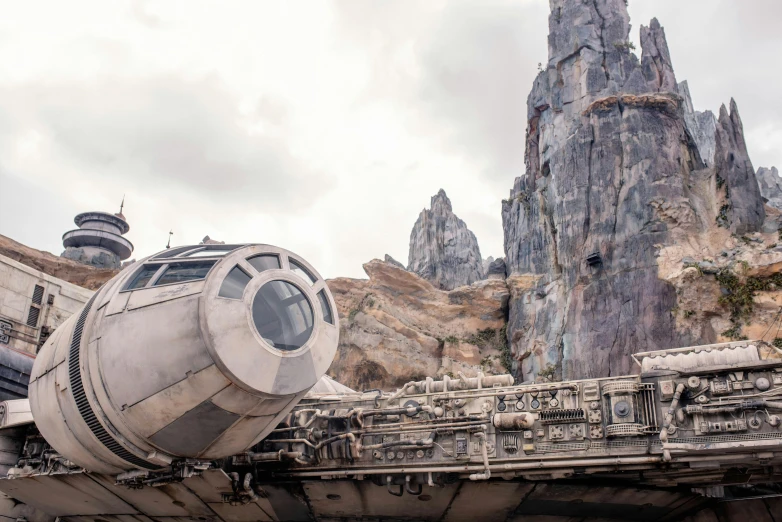 a star wars vehicle parked in front of a mountain, trending on unsplash, disney world, great a'tuin, grey, engines