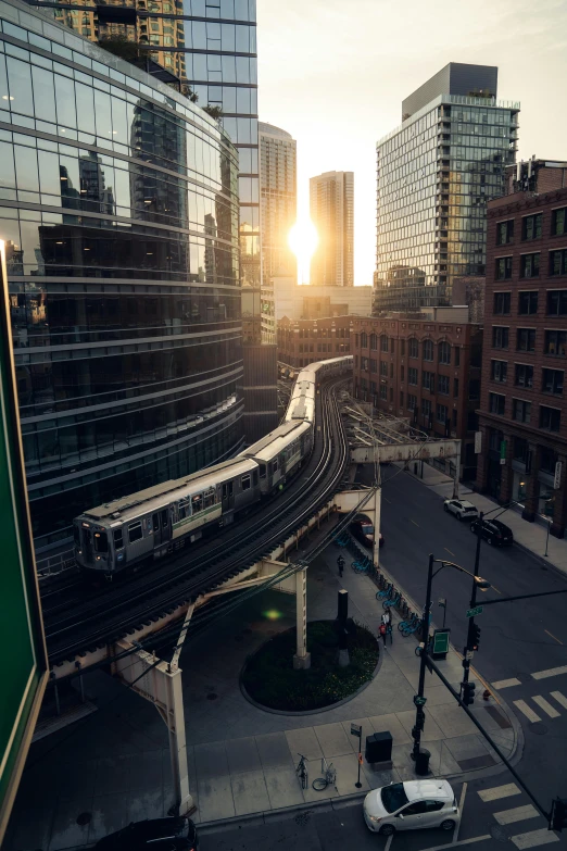 a train traveling through a city next to tall buildings, by Andrew Domachowski, unsplash contest winner, full morning sun, chicago, sunshaft, monorail station