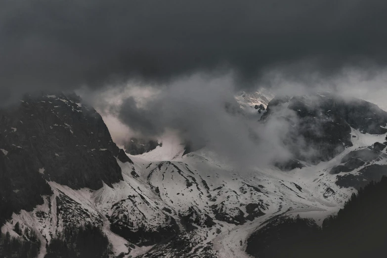 a large mountain covered in snow and clouds, by Sebastian Spreng, pexels contest winner, baroque, gloomy lighting, gloomy weather. high quality, grey, dark