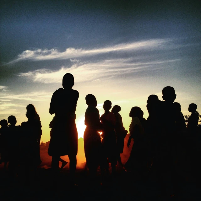 a group of people standing in front of a sunset, 1 9 8 4 ethiopian famine, lomo photograph, instagram photo, low-angle shot