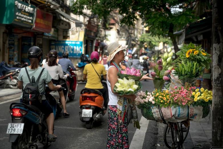 a woman is selling flowers on a busy street, riding a motorbike down a street, slide show, avatar image, conde nast traveler photo