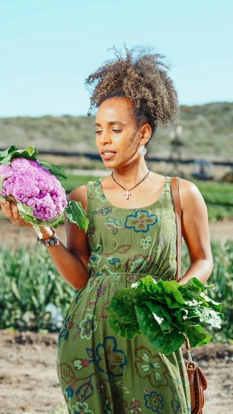 a woman standing in a field holding a bunch of vegetables, wearing pink floral chiton, nathalie emmanuel, profile image, green