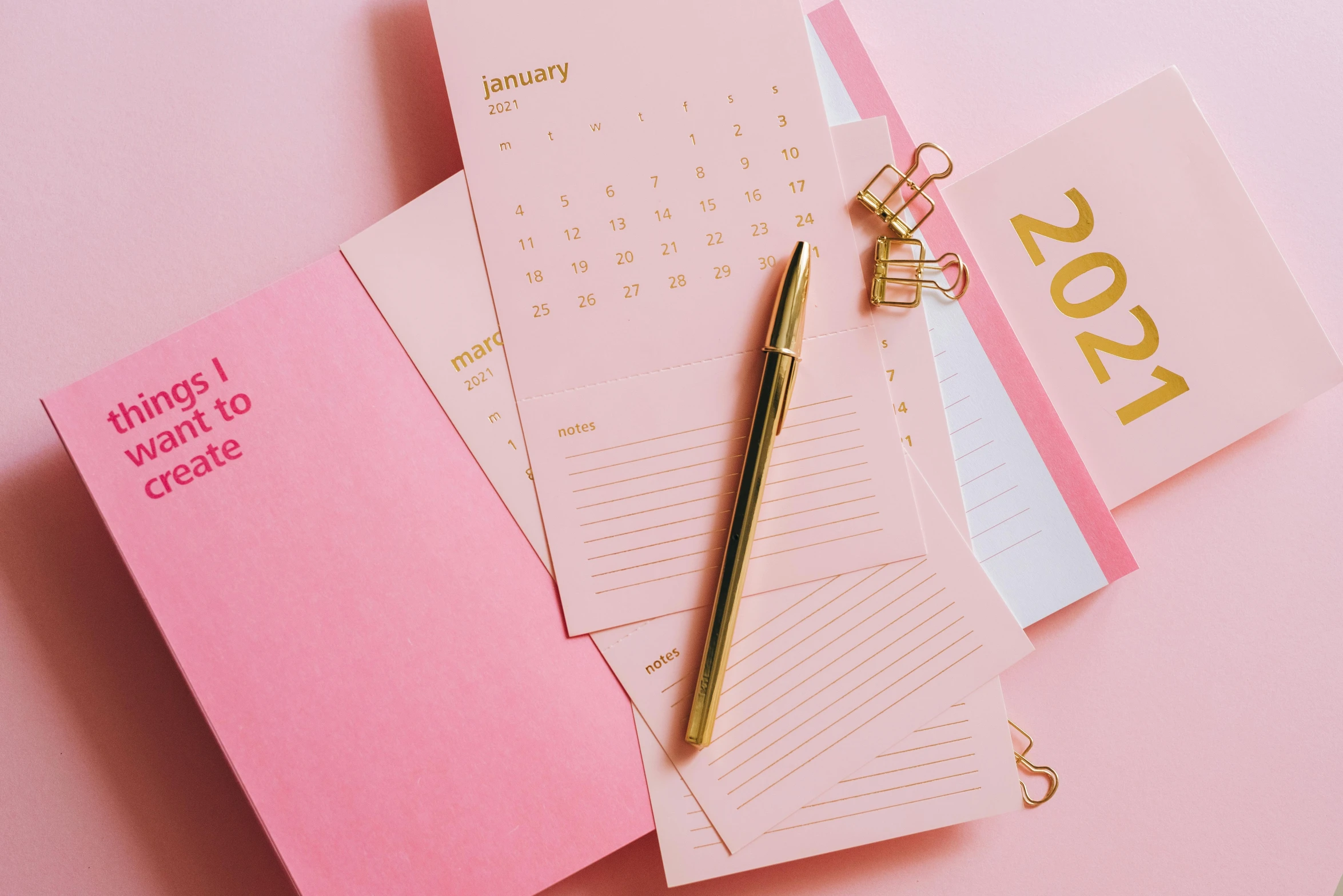 a pink notebook with a pen sitting on top of it, by Carey Morris, trending on pexels, happening, golden color scheme, knolling, holiday, thumbnail