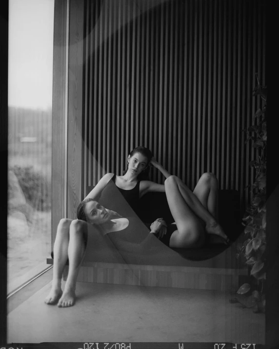 a black and white photo of a woman in a hammock, a black and white photo, by Emma Andijewska, unsplash contest winner, purism, two buddies sitting in a room, full of glass. cgsociety, two models in the frame, lesbian art