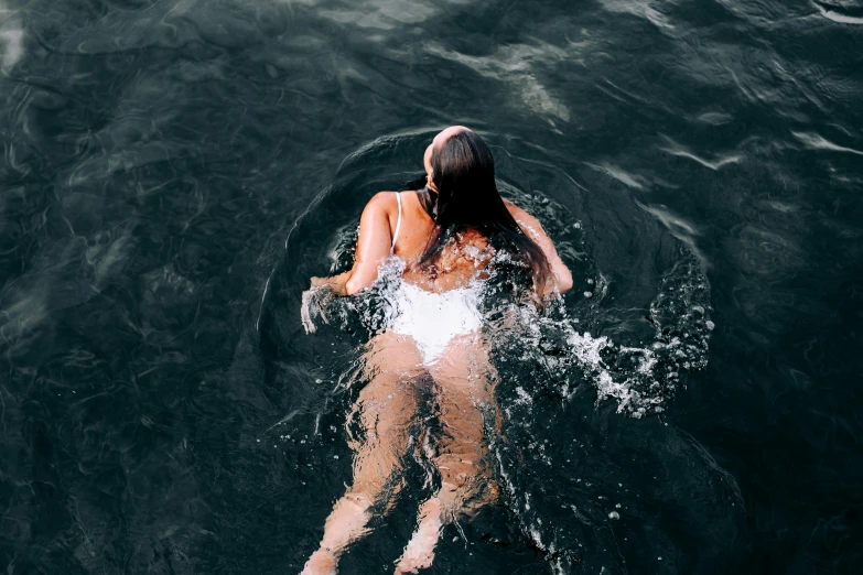 a woman swimming in a body of water, inspired by Elsa Bleda, pexels contest winner, carnal ) wet, backfacing, high angle shot, various posed