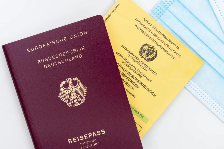 two passports sitting next to each other on a table, by Daniel Lieske, pexels, private press, on a yellow paper, german, 🦩🪐🐞👩🏻🦳, high-tech