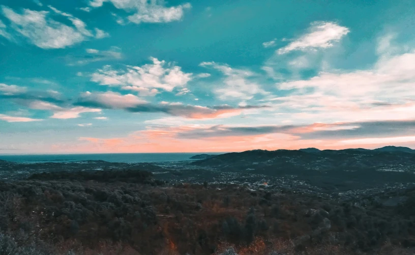 a person standing on top of a snow covered slope, pexels contest winner, blue sky with colorful clouds, distant town in valley and hills, croatian coastline, teal aesthetic