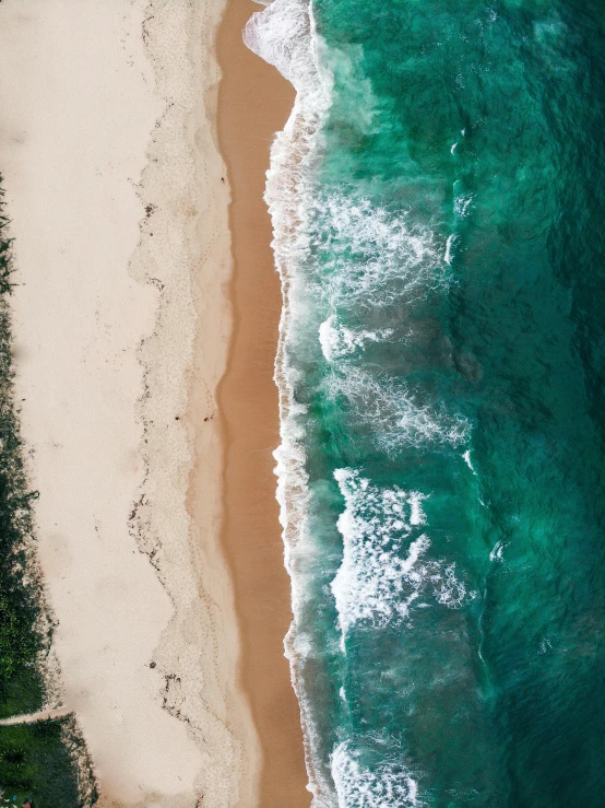 a large body of water next to a sandy beach, pexels contest winner, top - down photograph, manly, wild ocean background, 8k resolution”