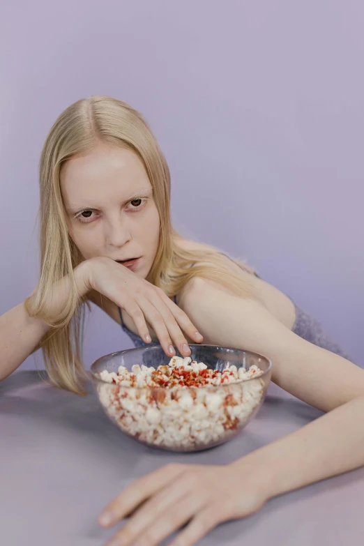 a woman sitting at a table with a bowl of popcorn, an album cover, inspired by Vanessa Beecroft, tumblr, intense albino, in style of britt marling, red contact lenses, transparent background