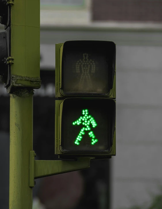 a traffic light with a green pedestrian sign on it, inspired by Bruce Nauman, trending on unsplash, low quality photo, multiple stories, alessio albi, exoskeletton