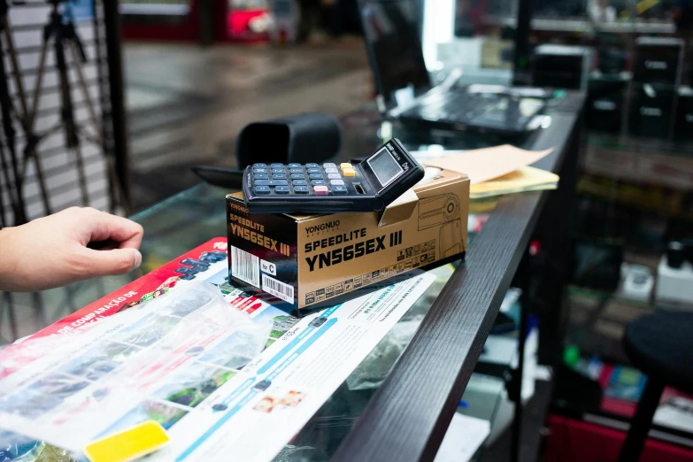 a phone sitting on top of a box on top of a table, ergodox, fantastic vendor interior, y3, thumbnail