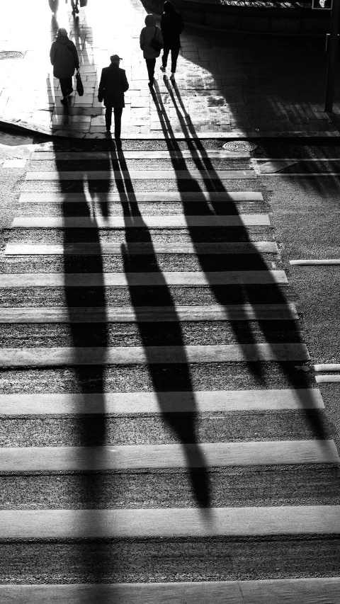 a group of people walking across a street, a black and white photo, conceptual art, caustics shadows, steps 50, striations, evening sunlight