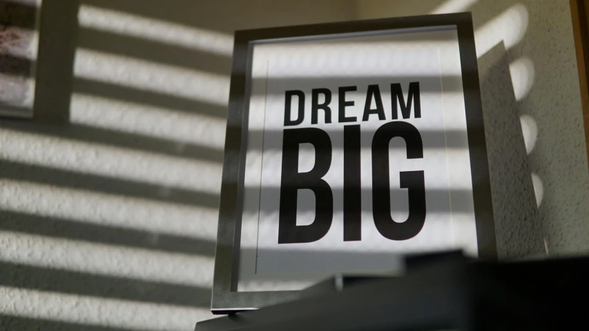 a picture of a sign that says dream big, by Sam Black, lightbox, indoor shot, photograph credit: ap, white