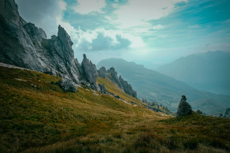 a view of the mountains from the top of a hill, by Andries Stock, pexels contest winner, tall stone spires, erosion algorithm landscape, switzerland, rocky grass field