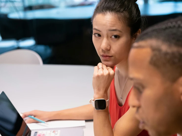 a couple of people sitting at a table with a laptop, by Jessie Algie, trending on unsplash, square, in a classroom, an asian woman, serious focussed look