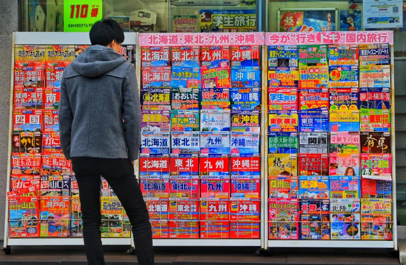 a man standing in front of a display of magazines, unsplash, ukiyo-e, drugstore, shopwindows, trending photo, breaking news