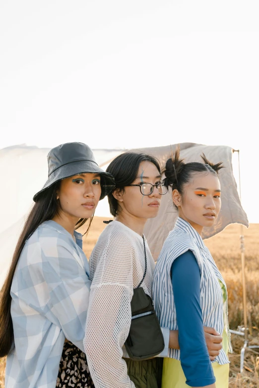 a group of women standing next to each other in a field, an album cover, inspired by Kim Tschang Yeul, unsplash, gutai group, wearing farm clothes, profile image, three heads, half asian