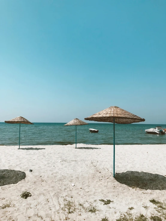 a group of umbrellas sitting on top of a sandy beach, body of water, black sea, profile image