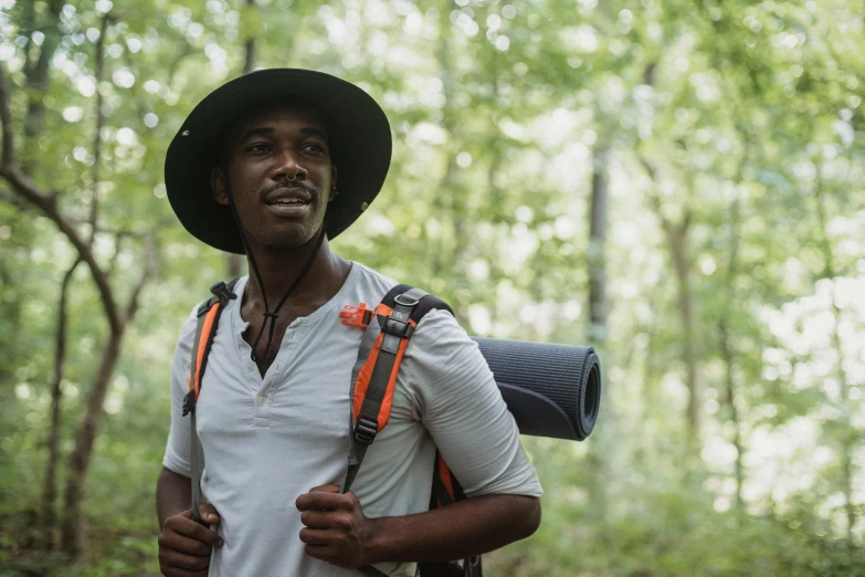 a man with a hat and backpack in the woods, a portrait, pexels contest winner, renaissance, man is with black skin, thumbnail, wearing adventure gear, film still from the movie