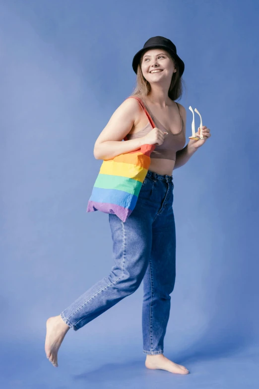 a woman in jeans and a hat holding a rainbow bag, sydney sweeney, slide show, lgbtq, nanae kawahara