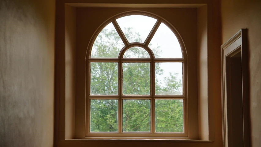 a white toilet sitting under a window in a bathroom, an album cover, inspired by William Nicholson, pixabay, arts and crafts movement, massive trees with warm windows, 80s interior with arched windows, photo of a beautiful window, smooth bevels