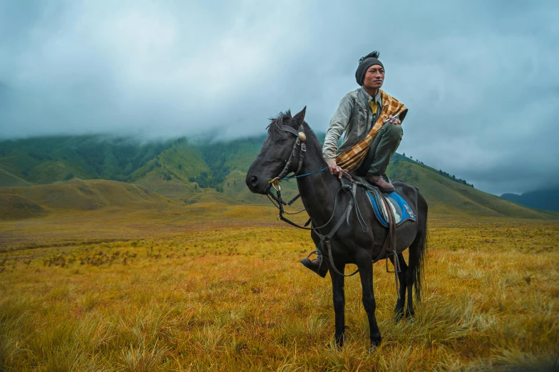 a man riding on the back of a black horse, an album cover, pexels contest winner, sumatraism, highlands, square, [ cinematic, nat geo