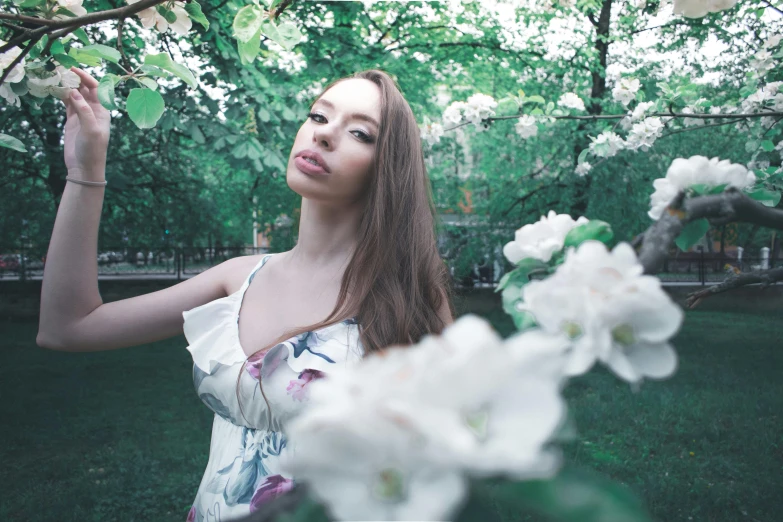 a woman standing in front of a tree with white flowers, inspired by Elsa Bleda, pexels contest winner, aestheticism, russian girlfriend, 8k selfie photograph, portrait sophie mudd, with a long white