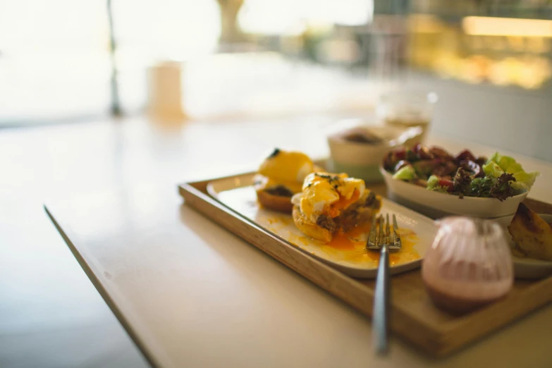 a close up of a plate of food on a table, by Jessie Algie, unsplash, eggs benedict cumberbatch, a wooden, yellow, daily specials