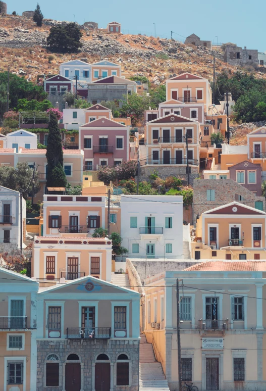 a group of buildings sitting on top of a hill, a colorized photo, trending on unsplash, neoclassicism, small port village, pathos, square, slide show